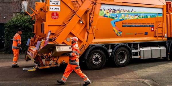 Twee afvalophalers bij een vuilniswagen